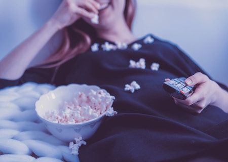 person watching TV with popcorn all over them