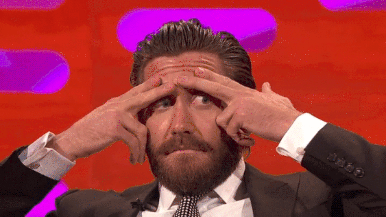 Gif. Jake Gyllenhaal covering his eyebrows with his fingers and looking around nervously.