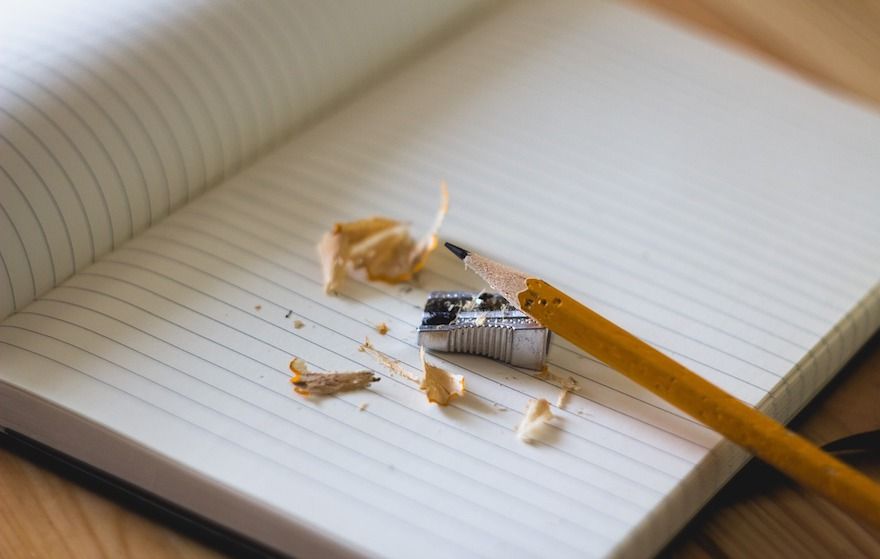 Open notebook and pencil with sharpener and pencil shavings