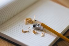 Open notebook and pencil with sharpener and pencil shavings