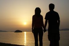 couple holding hands on a beach at sunset