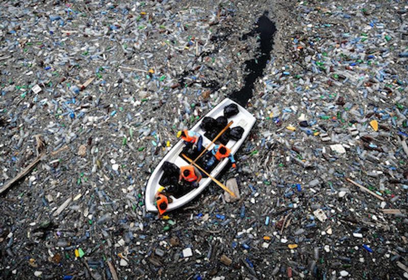 boat travelling through plastic pollution
