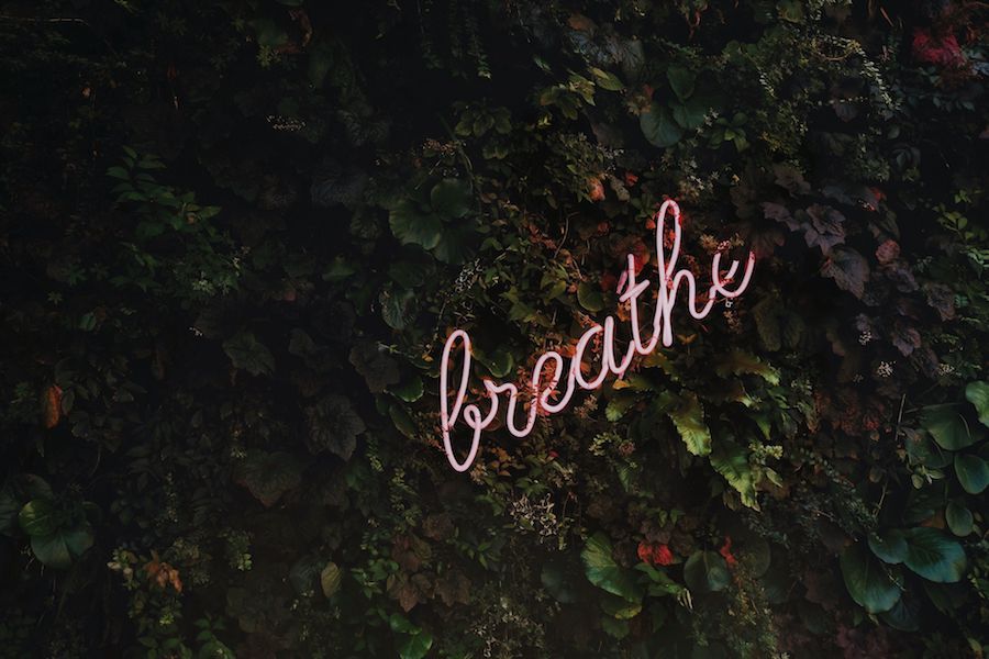 A neon sign of the word breathe.