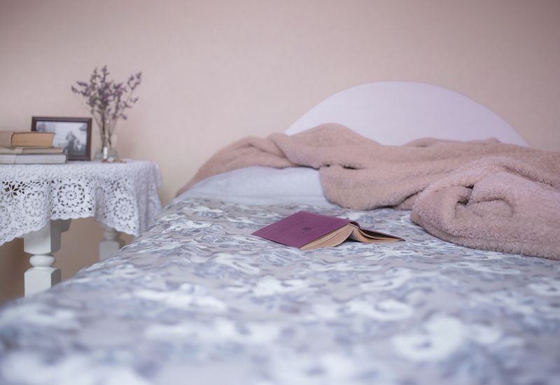 empty bed with a book laid on top