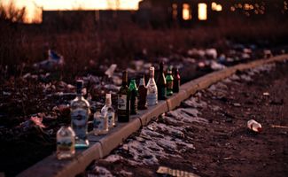 Empty glass bottles lined up on a wall