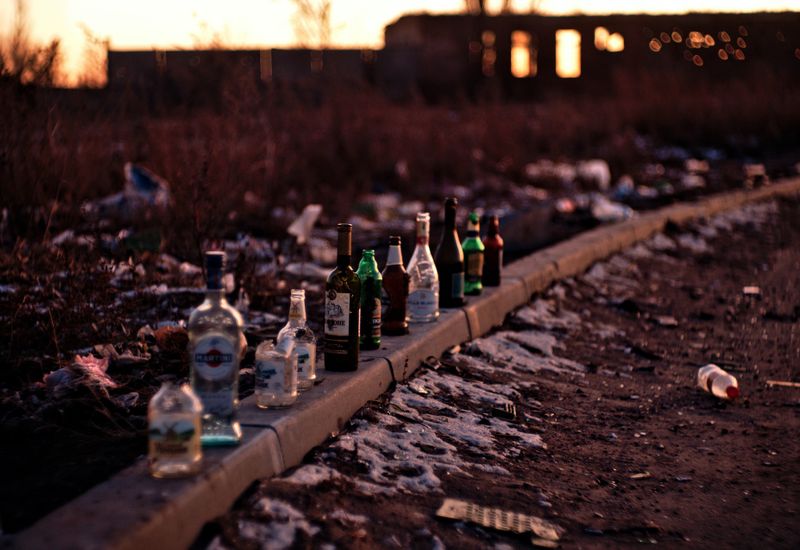 Empty glass bottles lined up on a wall