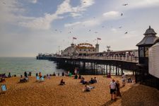 Picture of a busy Brighton beach with the Palace Pier in the middle of the shot