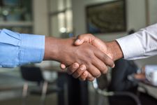 Close up of a handshake in a professional environment with a soft focus on the background