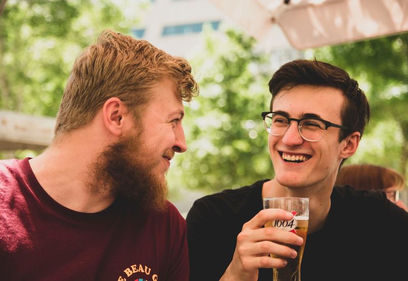 Two young men talking over a beer.
