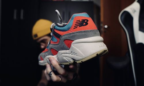 Person holding a pair of New Balance shoes