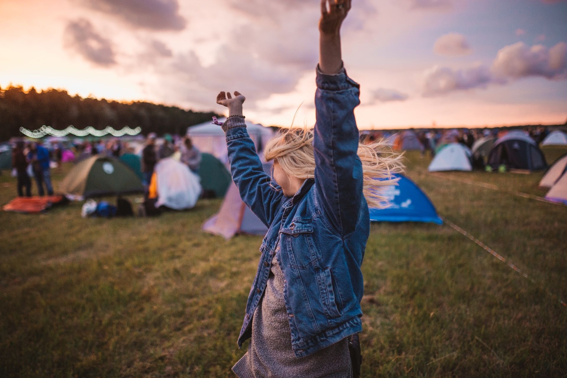 person dancing in front of tents at a festival