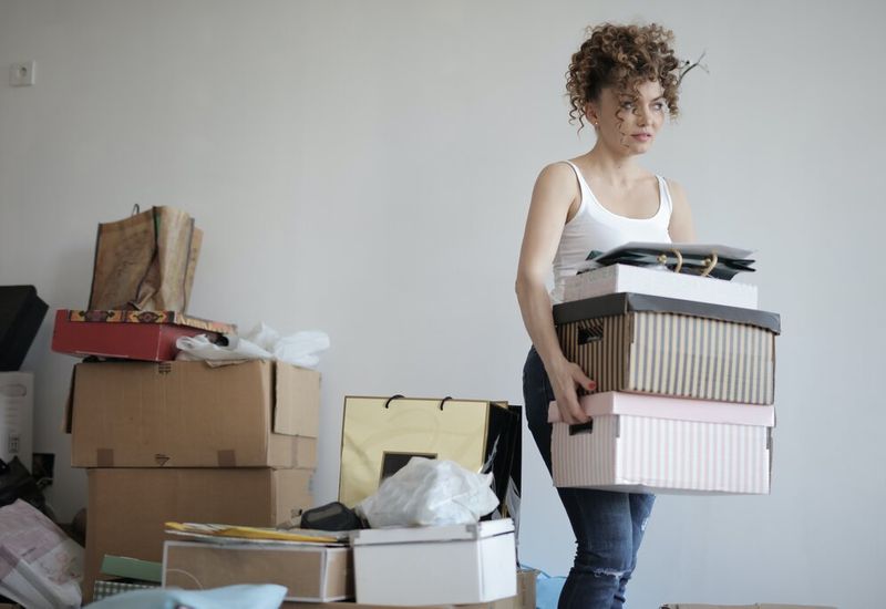 Young woman with stuff packed into boxes
