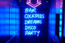 Neon sign that says "Bar, Cocktails, Dreams, disco, party"