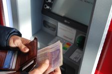 Person holding cash they have just taken out from an ATM