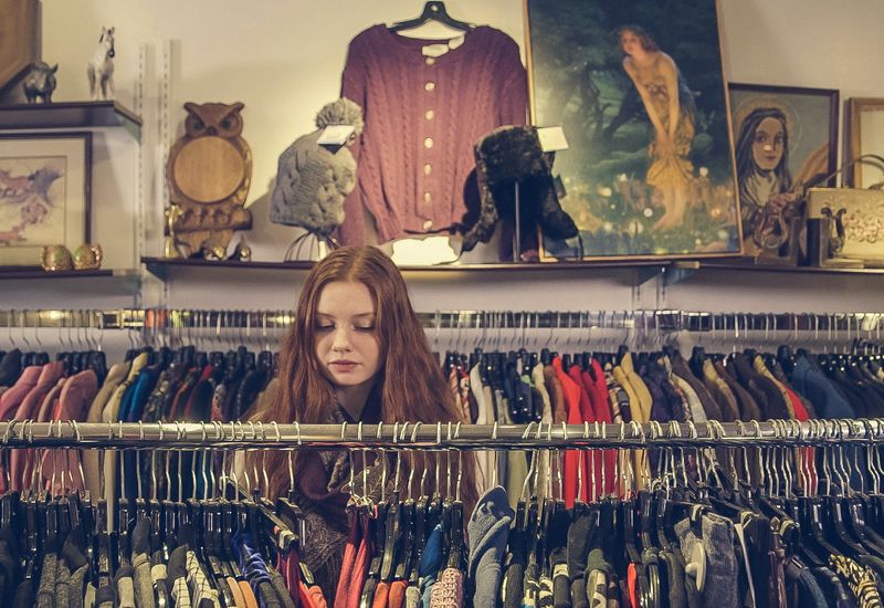 woman browsing the racks of a charity shop