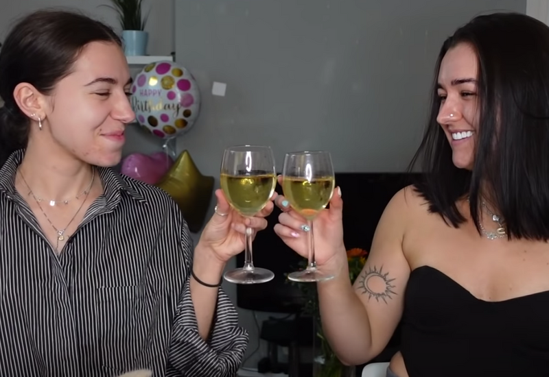 Megan on the right sharing a bottle of wine with her friend as they get ready