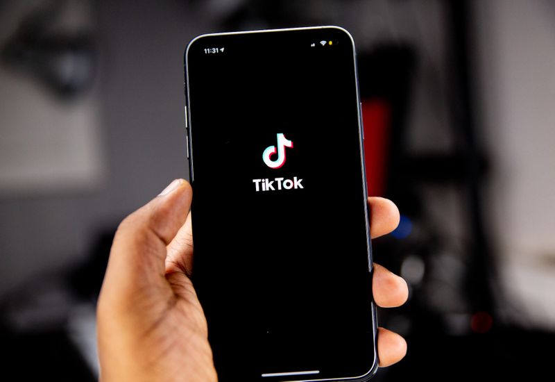 Phone in a hand with the TikTok app opening