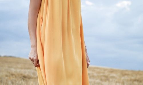 Woman wearing dress in a field.