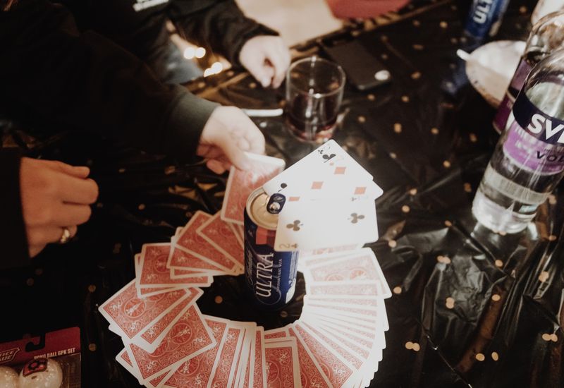 Cards around a drink as people play ring of fire