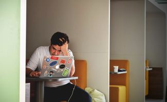 Student sat in a cubicle revising, seemingly stressed