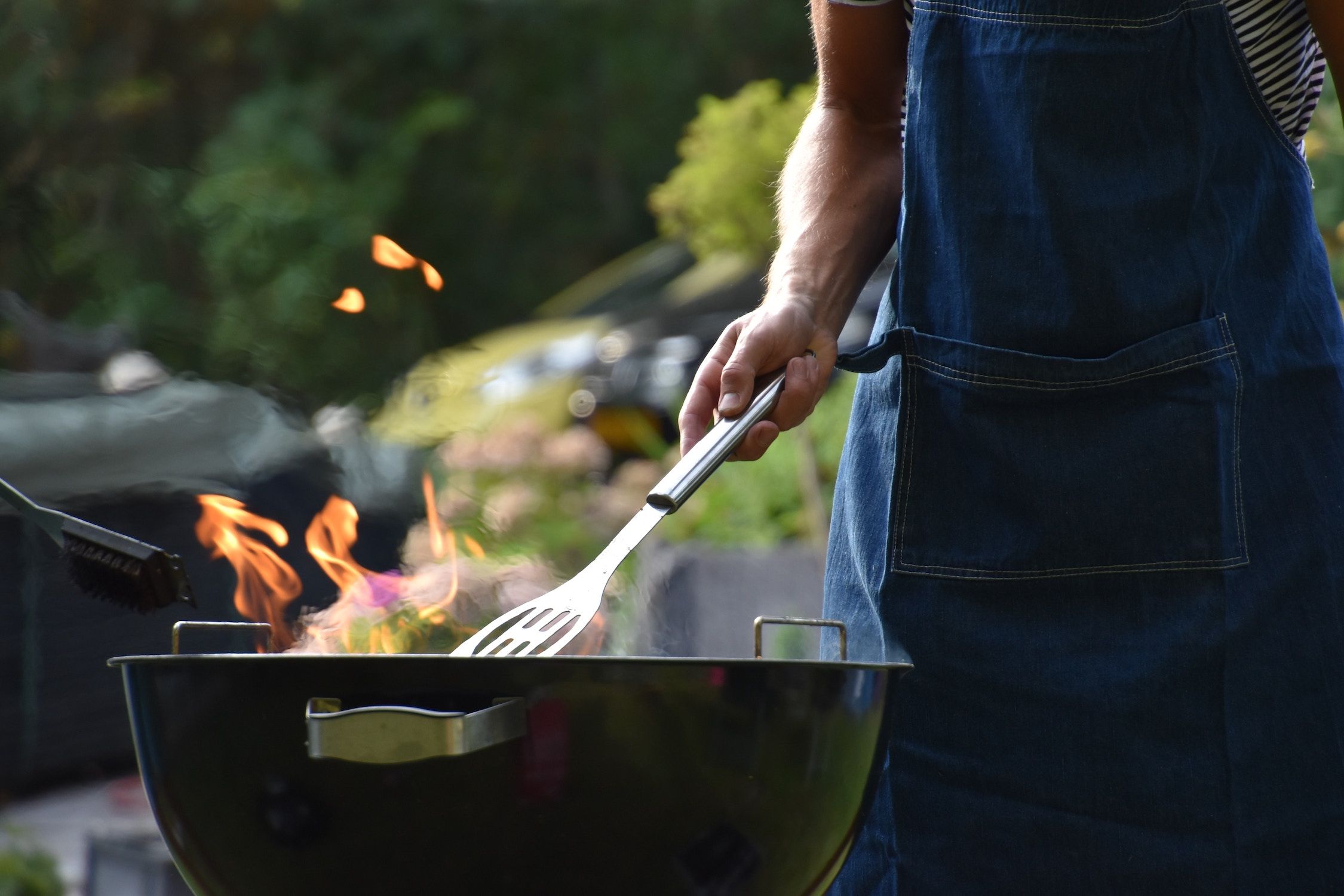man grilling food outside on a bbq