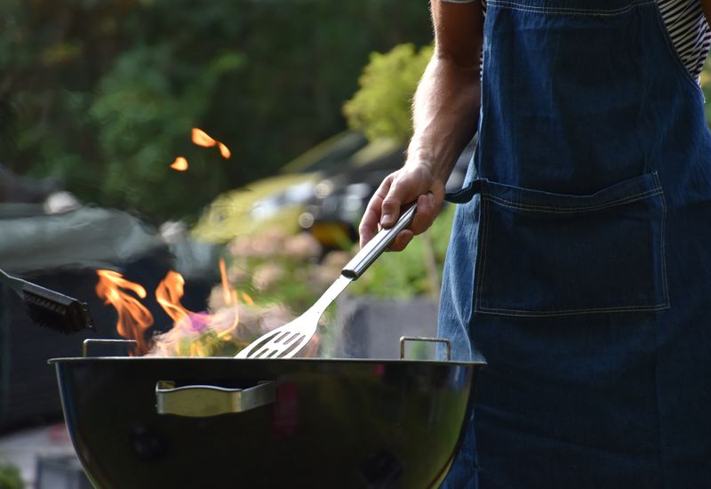 man grilling food outside on a bbq